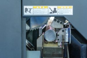 Detailed view of a metal cutting machine in operation, showcasing industrial machinery.